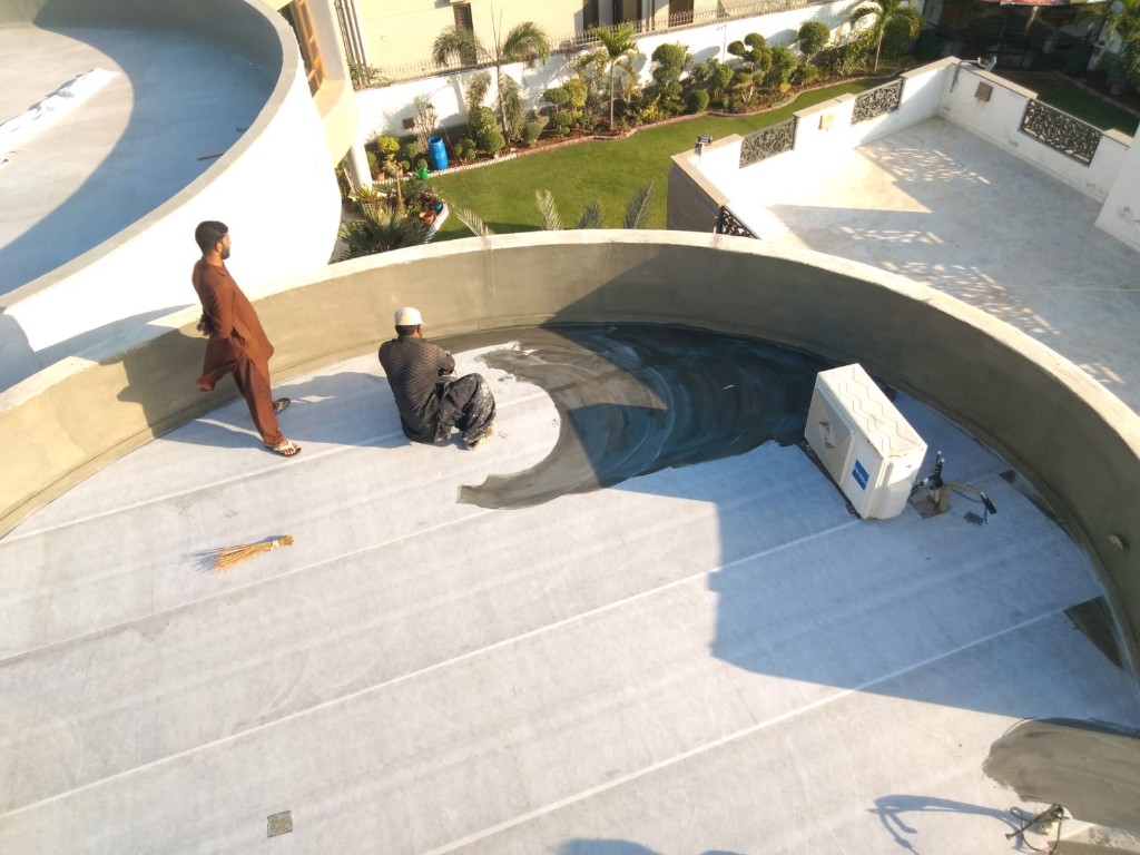 Worker on a high-rise corrugated roof overlooking the Karachi skyline